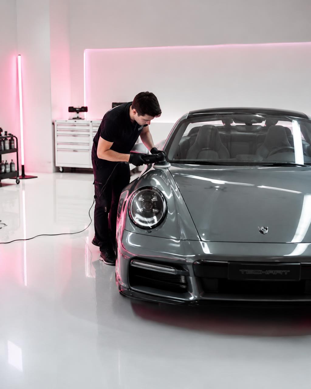 Technician polishing a sports car